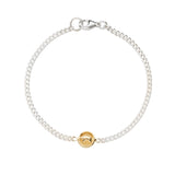 Silver bracelet with a gold charm on a white background
