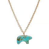 Turquoise stone bear pendant necklace on a gold chain against a white background
