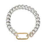 Thick silver chain bracelet with a oval hinge gold clasp on a white background