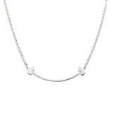 Silver necklace with a curved pendant  with a tiny bear on each side on a white background