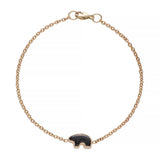 Gold bracelet with a onyx bear charm on a white background