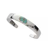 Sterling silver hand hammered cuff with a turquoise bear on a white background
