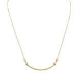 14k yellow Gold necklace with a curved bar, each side with a tiny bear and a bezel set diamond on a white background