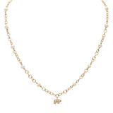 Gold necklace with small pearls and a gold pave bear pendant on a white background