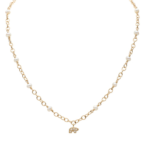 Gold necklace with small pearls and a gold pave bear pendant on a white background