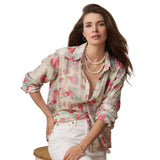 Woman wearing a floral blouse with a pearl necklace on a white background